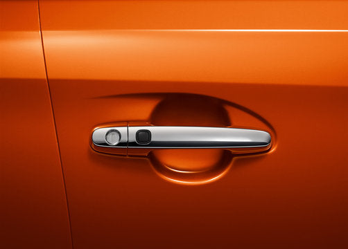 Close-up of car door handle assembly showing chrome exterior door handle, key lock cylinder, door handle trim cover, handle base bracket, connecting rod, latch mechanism, door lock actuator, and inner pull handle components