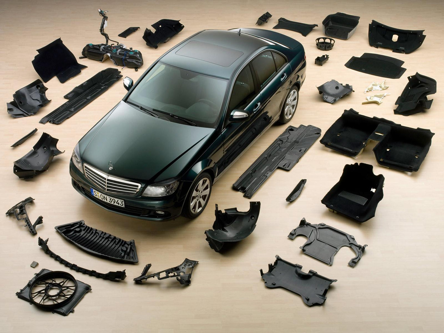 Car body kit with front bumper lip, rear diffuser, side skirts, wide fender flares, hood scoop, rear spoiler wing, front grille, and side splitters enhancing vehicle exterior styling